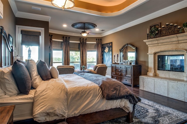 bedroom with dark hardwood / wood-style flooring, multiple windows, and a multi sided fireplace