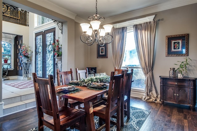 dining room with ornamental molding, dark hardwood / wood-style floors, a chandelier, and french doors