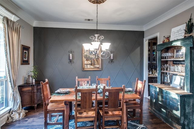 dining area featuring crown molding, dark wood-type flooring, and a chandelier