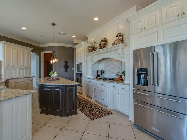 kitchen with light stone counters, light tile patterned floors, appliances with stainless steel finishes, a kitchen island, and pendant lighting