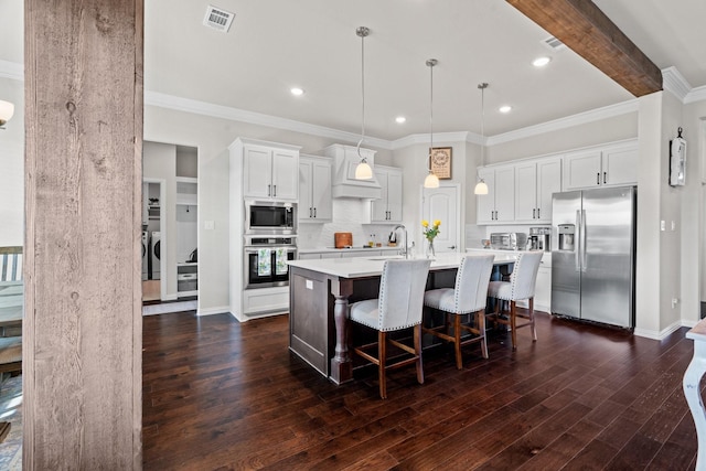 kitchen with stainless steel appliances, white cabinetry, a center island with sink, and pendant lighting