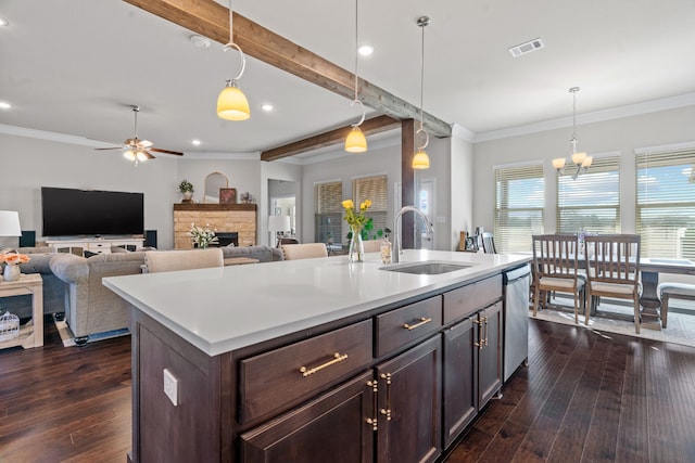 kitchen featuring dark brown cabinetry, sink, dishwasher, an island with sink, and pendant lighting