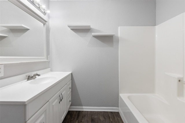 bathroom featuring hardwood / wood-style flooring, vanity, and shower / washtub combination