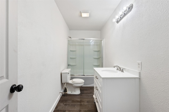 full bathroom with vanity, wood-type flooring, shower / bath combination with glass door, and toilet