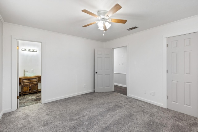 unfurnished bedroom with ceiling fan, ornamental molding, ensuite bathroom, and carpet