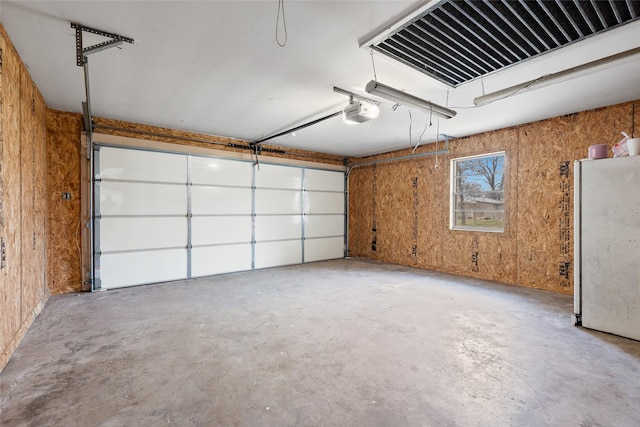 garage featuring a garage door opener and refrigerator