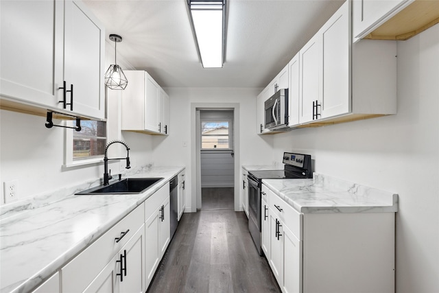 kitchen featuring white cabinetry, appliances with stainless steel finishes, sink, and pendant lighting