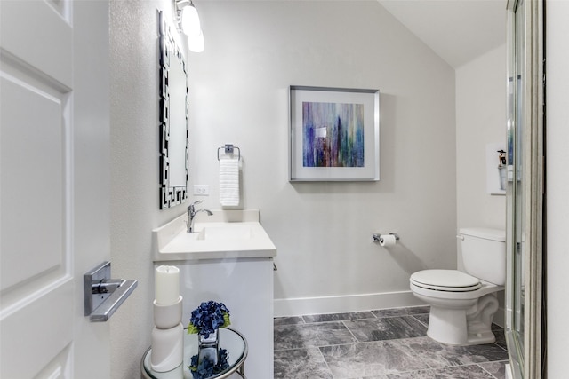 bathroom featuring lofted ceiling, vanity, and toilet