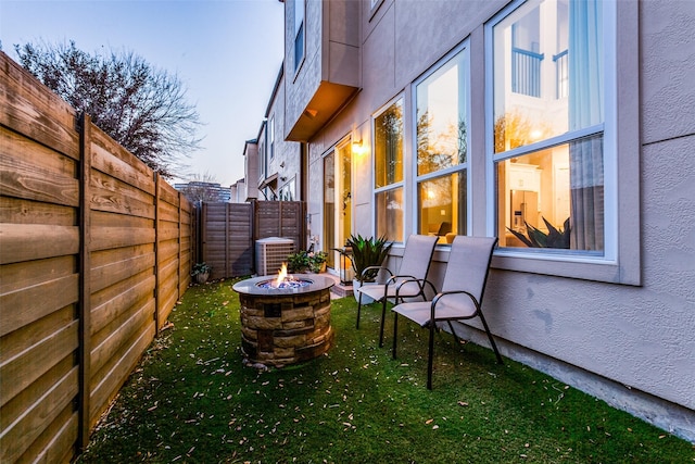 view of yard with central AC and an outdoor fire pit