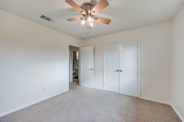 unfurnished bedroom featuring light colored carpet, a closet, and ceiling fan