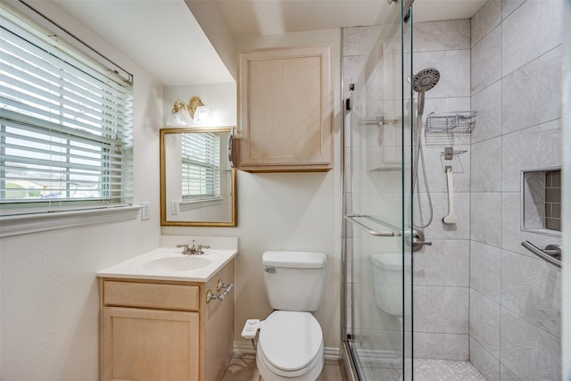 bathroom with walk in shower, vanity, and toilet