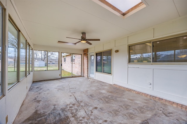 unfurnished sunroom featuring ceiling fan and a skylight