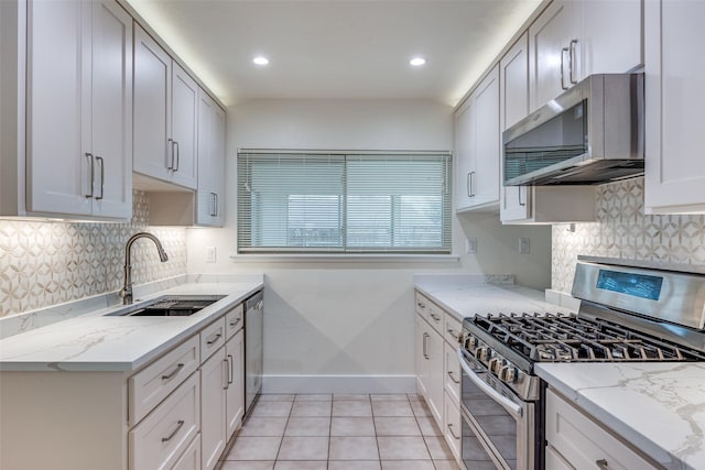 kitchen with light stone counters, stainless steel appliances, sink, and white cabinets