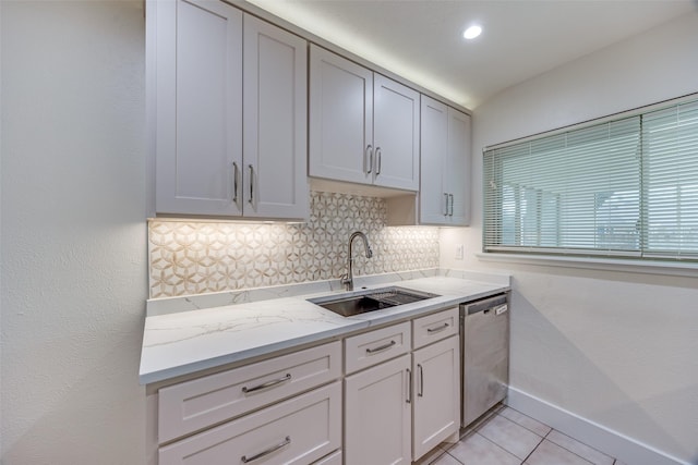 kitchen featuring sink, dishwasher, light stone countertops, light tile patterned flooring, and decorative backsplash