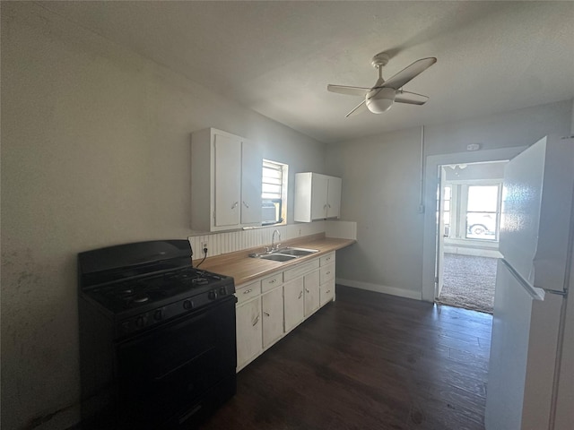 kitchen featuring dark hardwood / wood-style floors, white cabinetry, sink, white refrigerator, and black gas range