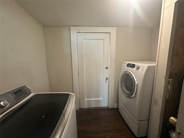 washroom with dark wood-type flooring and washing machine and clothes dryer