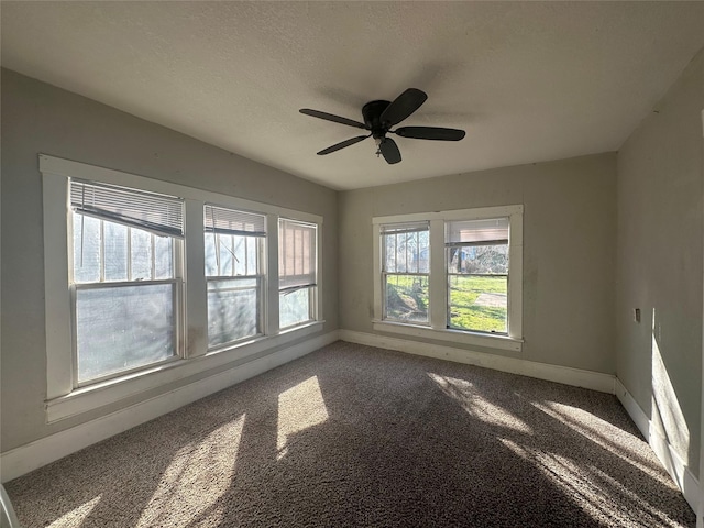 carpeted spare room featuring ceiling fan and a textured ceiling