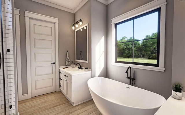 bathroom with hardwood / wood-style flooring, ornamental molding, vanity, and a bathing tub