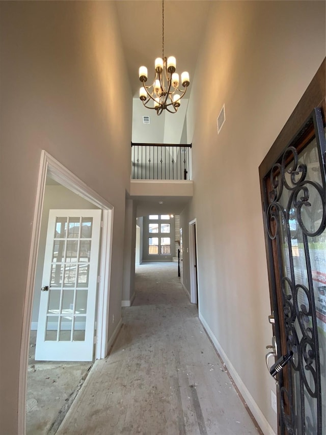 foyer entrance with a towering ceiling and a chandelier