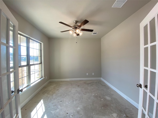 empty room featuring ceiling fan and french doors