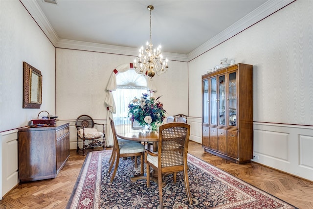 dining space with ornamental molding, light parquet flooring, and a chandelier