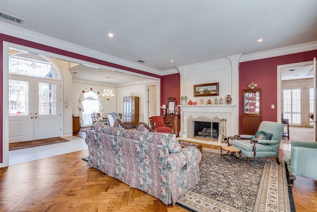 living room with a large fireplace, light parquet flooring, crown molding, and french doors