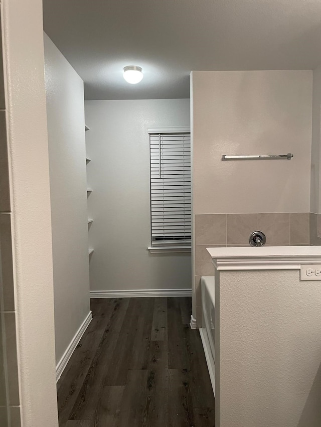 bathroom featuring hardwood / wood-style floors and a tub to relax in