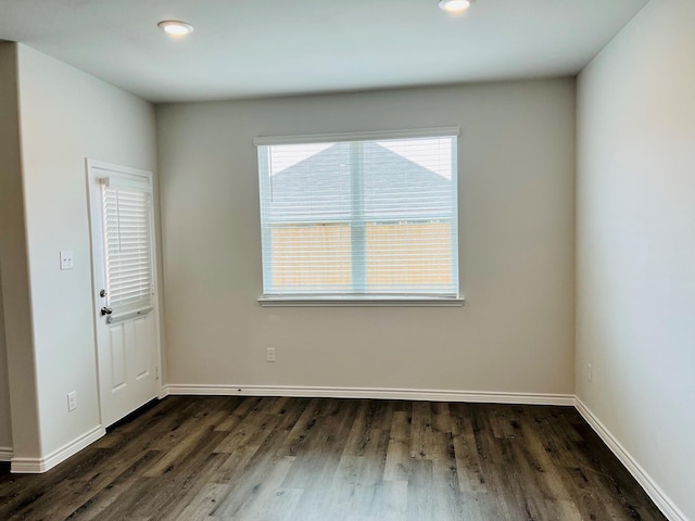 unfurnished room with dark wood-type flooring