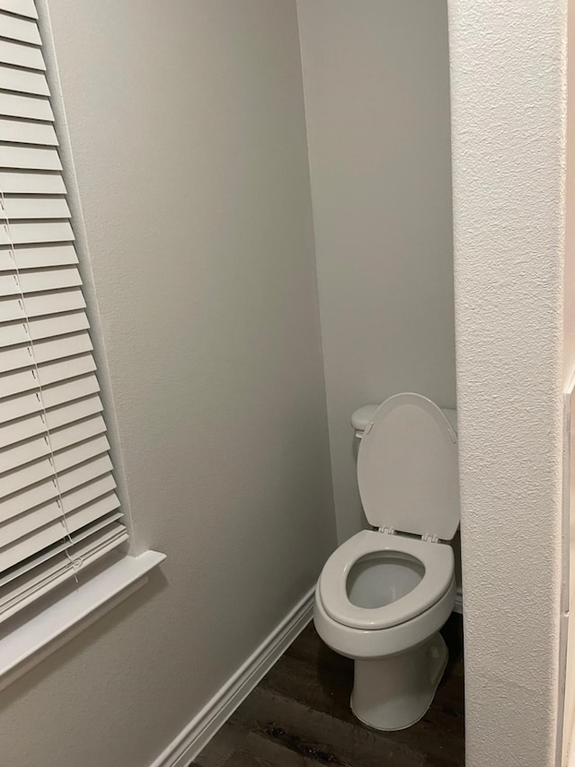 bathroom with hardwood / wood-style flooring and toilet