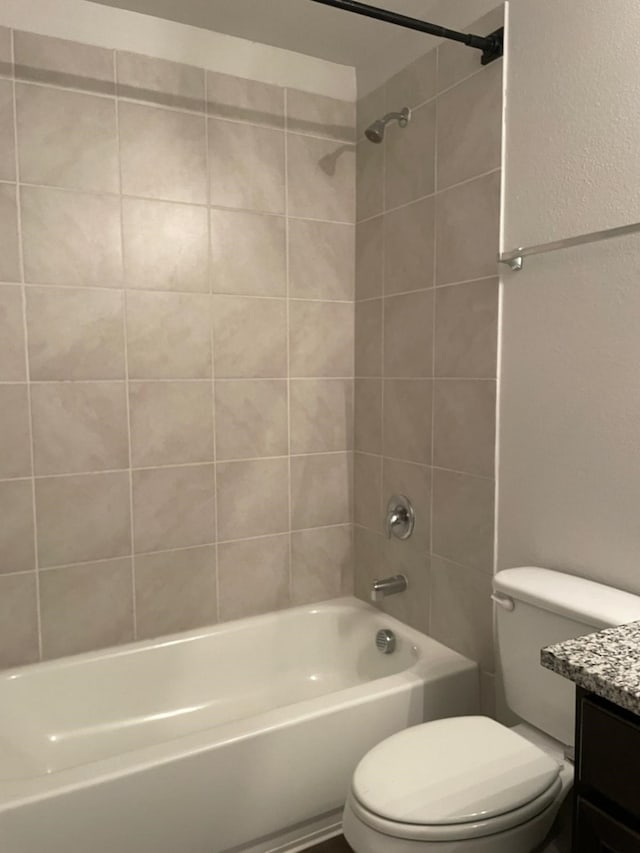 full bathroom with vanity, tiled shower / bath combo, and toilet