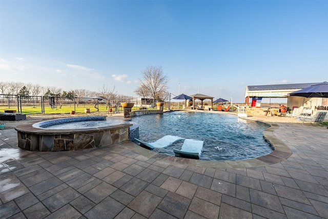 view of swimming pool with a patio, a gazebo, pool water feature, and an in ground hot tub