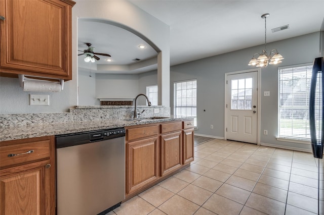 kitchen featuring sink, stainless steel dishwasher, light stone counters, light tile patterned floors, and ceiling fan with notable chandelier