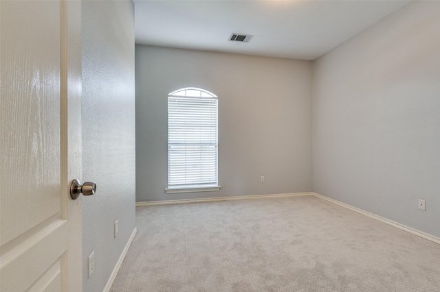 spare room featuring light colored carpet