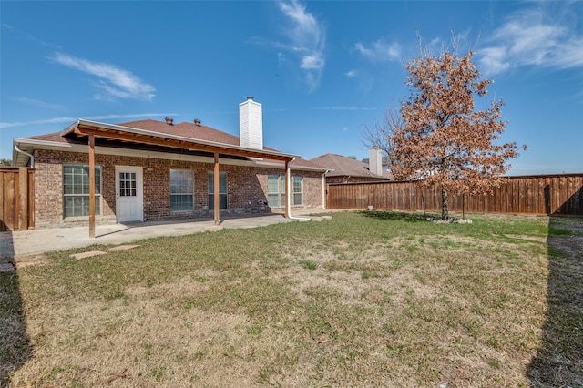 back of property featuring a patio and a yard