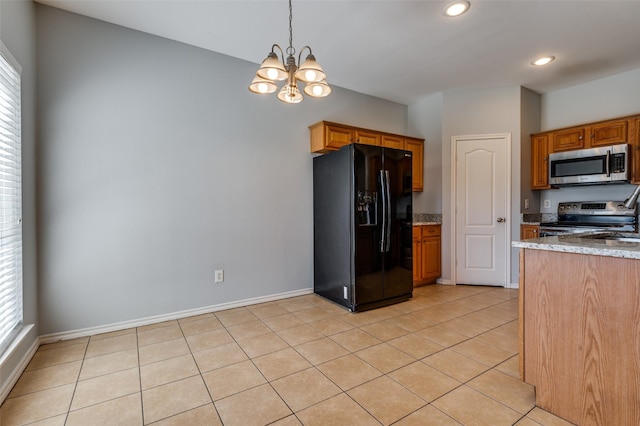 kitchen with light stone countertops, an inviting chandelier, appliances with stainless steel finishes, light tile patterned flooring, and pendant lighting