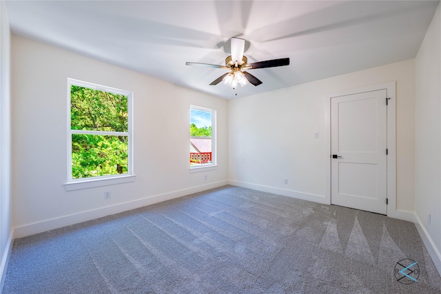 carpeted spare room with baseboards and ceiling fan