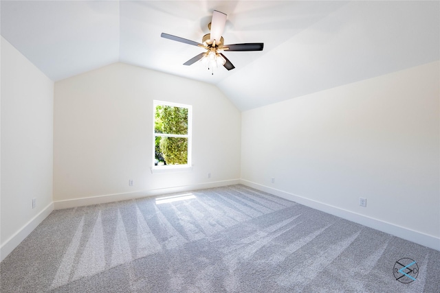 empty room featuring baseboards, a ceiling fan, carpet, and lofted ceiling