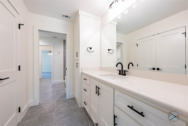 bathroom with vanity, baseboards, and visible vents