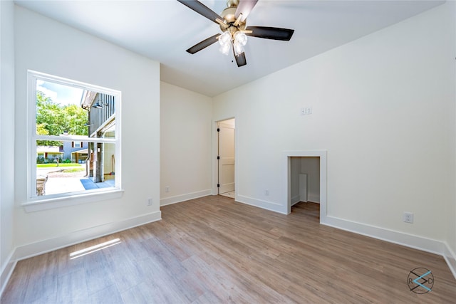 unfurnished room featuring light wood finished floors, ceiling fan, and baseboards