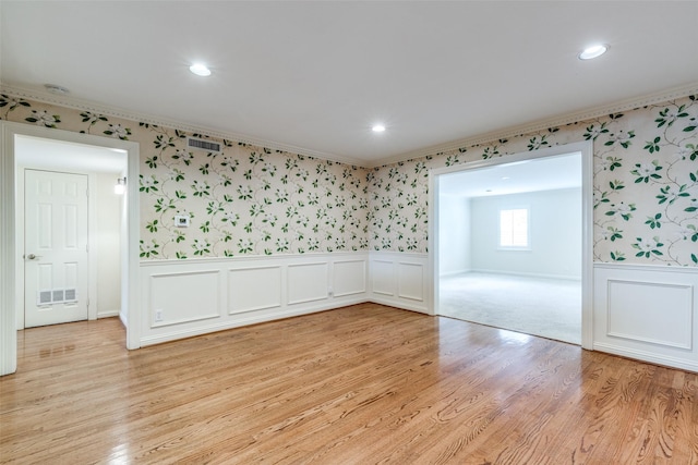 unfurnished room with crown molding and light wood-type flooring