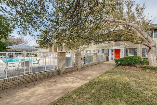 obstructed view of property featuring a community pool and a patio area