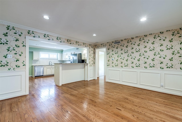 kitchen with white cabinetry, sink, kitchen peninsula, stainless steel appliances, and light wood-type flooring