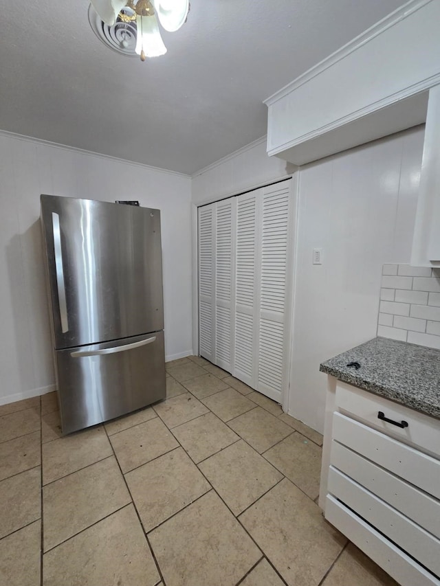1714 Laurel Rd, Gainesville, TX 76240 - kitchen with freestanding refrigerator, light tile patterned floors, stone countertops, and tasteful backsplash