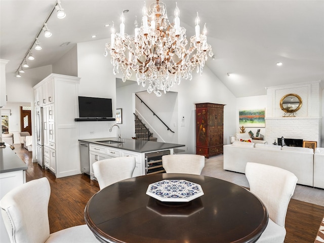 dining area featuring sink, dark wood-type flooring, beverage cooler, and high vaulted ceiling