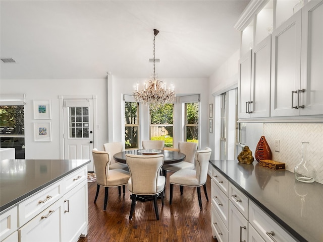 dining area featuring dark hardwood / wood-style floors and a chandelier