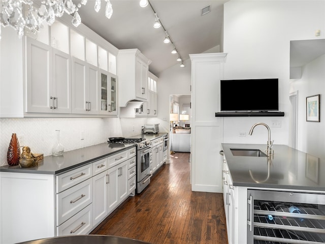 kitchen featuring white cabinetry, stainless steel range with gas cooktop, beverage cooler, and sink