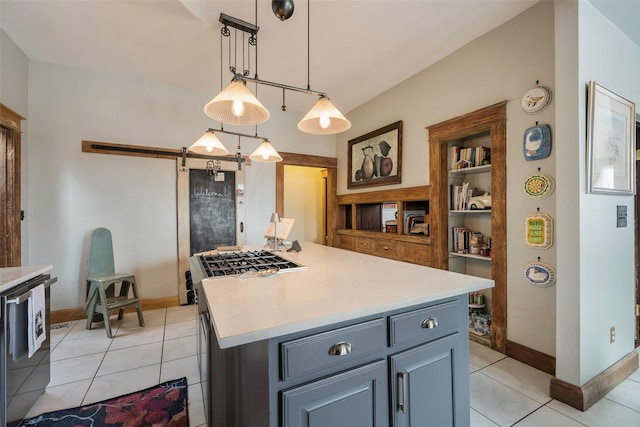 kitchen with gray cabinets, decorative light fixtures, a center island, and light tile patterned floors