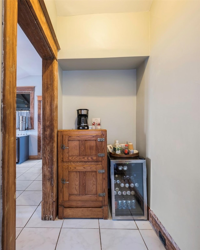 bar with beverage cooler and light tile patterned flooring