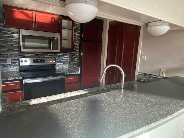 kitchen with dark countertops, tasteful backsplash, appliances with stainless steel finishes, and dark brown cabinets