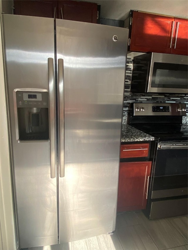 kitchen with stainless steel appliances and dark stone counters